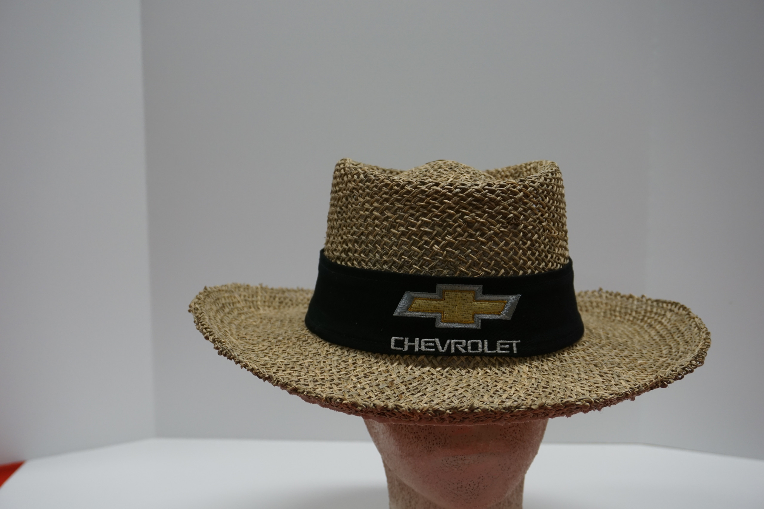 Straw hat on mannequin head with logo